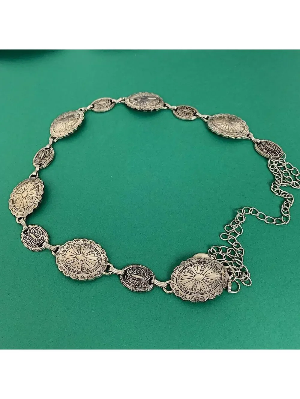Silver western belt with silver buckle and metal sun and moon charms. Fits most